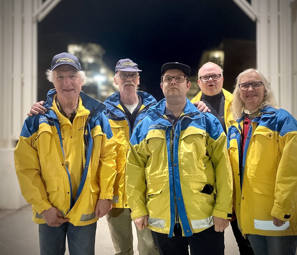 Gruppbild på fem nattvandrare i Nödinge klädda i gulblå jackor.