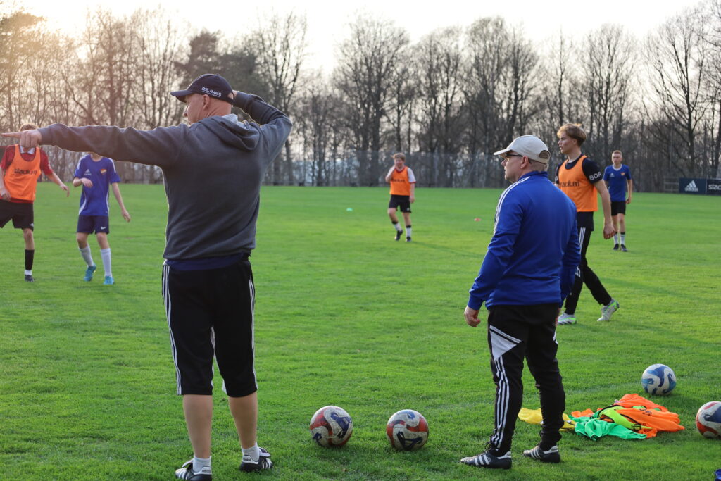 Ola Larsson och Jan Bengtsson står vid sidlinjen och instruerar spelarna på plan.
