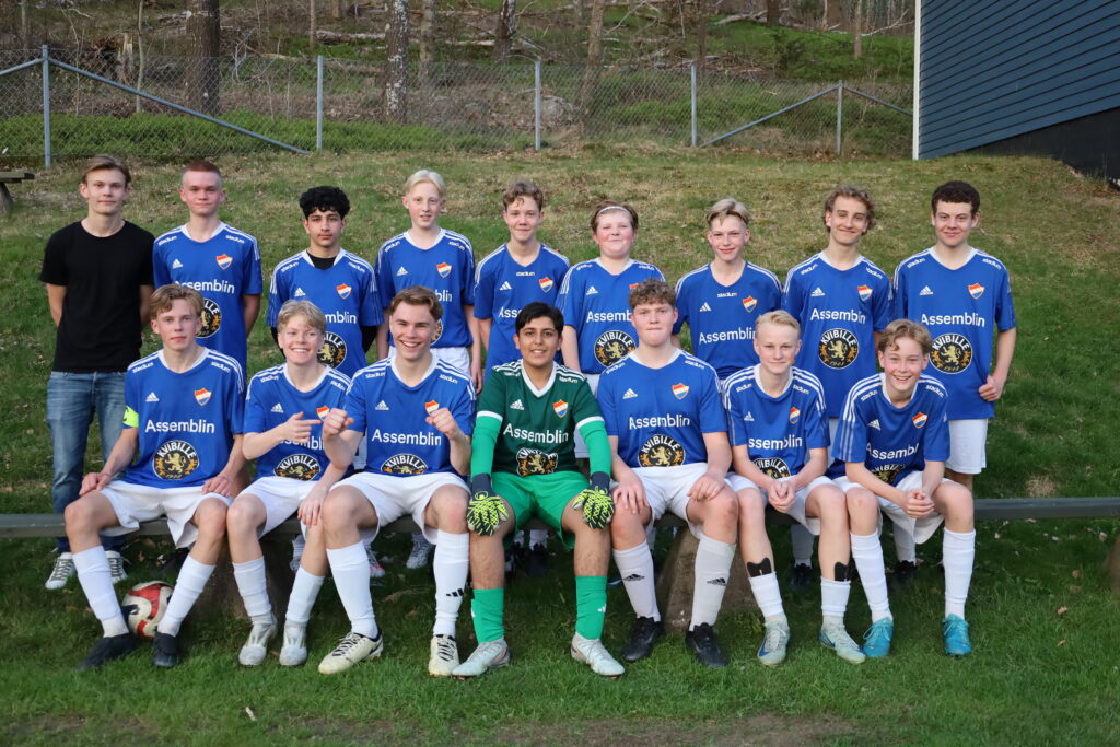 Lagbild på Kvibille BK. de har sitt blå matchställ på sig och ler mot kameran.