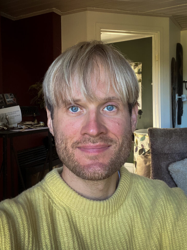 Selfie på Alexander, leendes i gul tröja. 